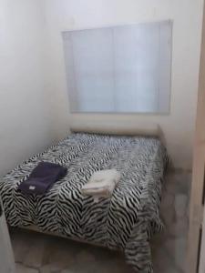 Bett in einem Zimmer mit Zebra-Abdruck in der Unterkunft Casa de Campo-Linda Vista-SOUSAS in Campinas