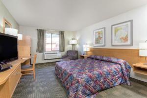 a hotel room with a bed and a flat screen tv at Super 8 by Wyndham Lacey Olympia Area in Lacey