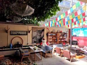 una habitación con mesa y sillas y una habitación con banderas coloridas en The Moon Bird Hostel en Shangri-La