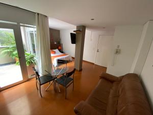 sala de estar con mesa de cristal y cama en Hotel Juliette Bogota, en Bogotá