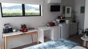 a room with a bed and two desks and a microwave at Applecross Sanctuary in Cambridge