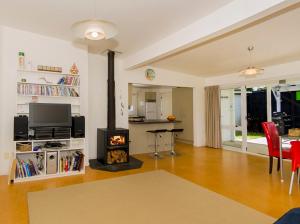 a living room with a fireplace and a stove at Gone Coastal - Whangamata Holiday House in Whangamata
