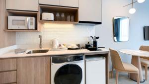 een keuken met een wasmachine en een wastafel bij Staybridge Suites Bangkok Thonglor, an IHG Hotel in Bangkok