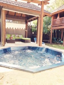a large hot tub in a backyard with a pergola at Ximenoa Rivers Villa Relax in Jarabacoa