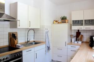 a kitchen with white cabinets and a sink at Ferienhaus Am Stadtpark in Bad Harzburg