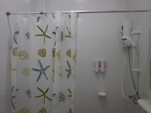 a bathroom with a shower curtain with fish on it at The Theatre Villa in Bang Saphan