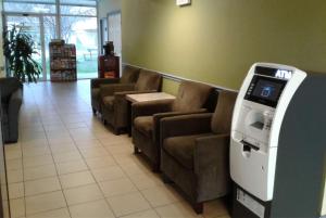 a atm machine in a waiting room with couches at Days Inn by Wyndham Alexandria South in Alexandria