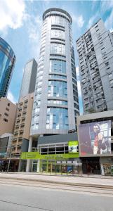 a tall building with a billboard in a city at Hotel Ease Causeway Bay in Hong Kong