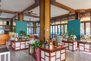 Phi Phi Long Beach Resort & Villa-SHA Extra Plus في جزيرة في في: مطعم مع مجموعة طاولات في الغرفة