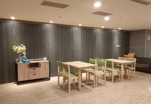 a waiting room with tables and chairs and a wall at Urbanone Hotel in Taipei