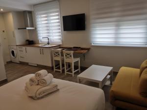 a room with a bed and a kitchen with a table at Alumar Apartamentos Muxia in Muxia