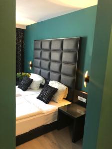 ケルステルバッハにあるHotel Athen Kelsterbach Frankfurt Airportのベッドルーム1室(大型ベッド1台、黒いヘッドボード付)