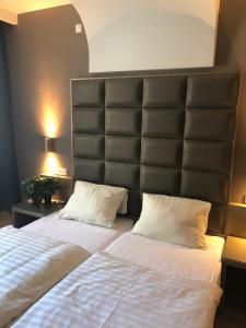 ケルステルバッハにあるHotel Athen Kelsterbach Frankfurt Airportのベッドルーム1室(ベッド2台、大型ヘッドボード付)