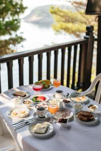 a table with plates of food and glasses of orange juice at Theoxenia Apartments in Ormos Panagias +65 photos