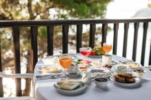 a table with plates of food and glasses of orange juice at Theoxenia Apartments in Ormos Panagias