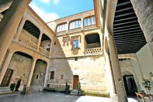 a large building with a bunch of windows and a staircase at Posada Real Castillo del Buen Amor in Villanueva de Cañedo