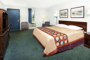 a hotel room with a large bed and a television at Super 8 by Wyndham Taylorville IL in Taylorville