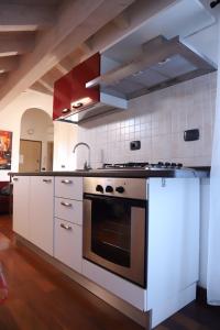 uma cozinha com armários brancos e um forno em Mansarda Ivy em Finale Ligure