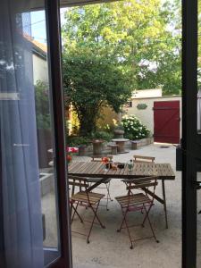 d'une table de patio et de chaises à l'extérieur d'une porte coulissante en verre. dans l'établissement Le Clos Moussy, à Moussy