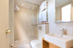 a bathroom with a sink and a shower and a toilet at Hôtel Cordelia Opéra-Madeleine in Paris +62 photos