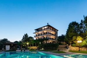 a large building with a pool in front of it at Theoxenia Apartments in Ormos Panagias