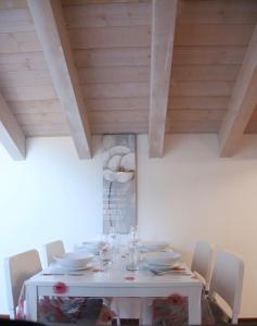 uma mesa de jantar com pratos brancos em Mansarda Ivy em Finale Ligure
