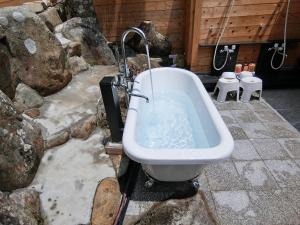 a bathroom with a bath tub and a toilet at Shirahama Meiji Villa in Shirahama