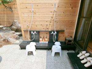 a outdoor shower with a bench and white stools at Shirahama Meiji Villa in Shirahama