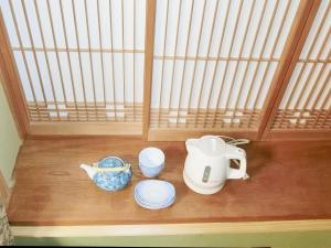 a table with a tea kettle and plates on it at Shirahama Meiji Villa in Shirahama