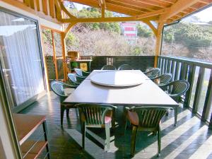 a table and chairs on a screened porch at Shirahama Meiji Villa in Shirahama