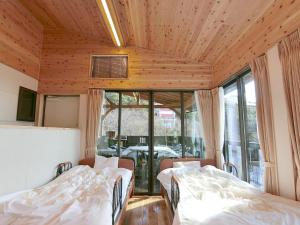 a room with two beds and a dining room with a table at Shirahama Meiji Villa in Shirahama