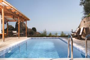 a swimming pool in a villa with a view of the ocean at Villa Rocale in Argassi