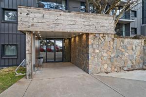 una pared de piedra con un banco frente a un edificio en Chalet Apartments - Mt Buller Apartment Rentals, en Mount Buller