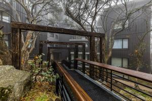 a wooden bridge in front of a building at Chalet Apartments - Mt Buller Apartment Rentals in Mount Buller