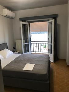 a bedroom with a bed and a large window at Beautiful view of poros in Galatas