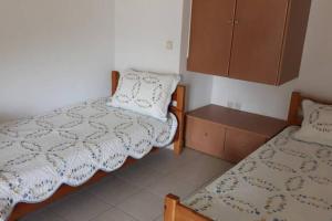 a bedroom with two beds and a cupboard at Σπίτι στο βουνό αλλά μια ανάσα από τη θάλασσα in Palaiokhórion