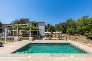 ein Swimmingpool mit Stühlen und ein Haus in der Unterkunft Finca Can Blai in Capdepera