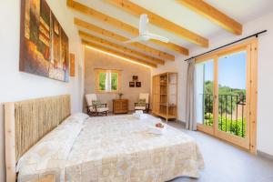 ein Schlafzimmer mit einem Bett und einem großen Fenster in der Unterkunft Finca Can Blai in Capdepera