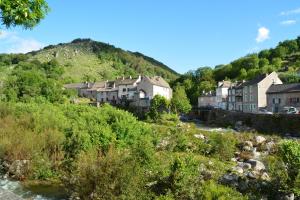 un village avec une rivière et des maisons sur une colline dans l'établissement Gite Mont Lozère, à Le Pont-de-Montvert
