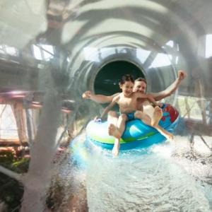 two young boys riding on a raft in a water park at Logement cosy proche Paris et Disneyland in Villiers-sur-Marne