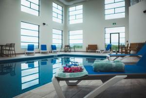 a swimming pool with chairs and a table in front of it at Quality Hotel & Conference Centre in Edmundston