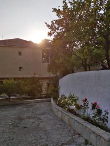 eine Steinmauer neben einem Gebäude und einige Blumen in der Unterkunft Ηotel Della in Parga + 26 Fotos