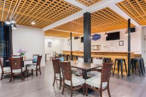 a restaurant with wooden ceilings and tables and chairs at The Blu Hotel Blue Ash Cincinnati, Ascend Hotel Collection in Blue Ash