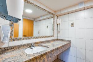 a bathroom with a sink and a mirror at Hotel Freiensteinerhof Superior in Sankt Peter-Freienstein