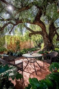 a patio with a table and chairs under a tree at Lucy's Cottage in Marananga