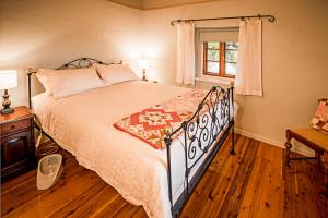 1 dormitorio con cama y ventana en Lucy's Cottage, en Marananga