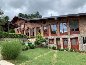 a large brick house with a lawn in front of it at Kuća za odmor "Karalic" in Ležimir