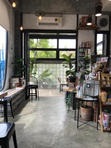 een kamer met tafels en stoelen en een groot raam bij YOJI House and Cafe in Ban Wiang