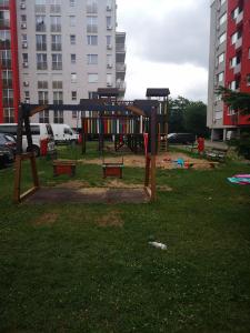 an empty playground in a park with tall buildings at Relaxing Spa Apartment in Arad