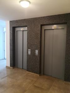 uma fila de três elevadores num edifício em Relaxing Spa Apartment em Arad